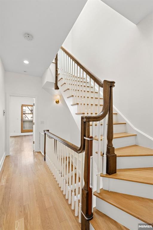 stairway with recessed lighting, baseboards, and wood finished floors