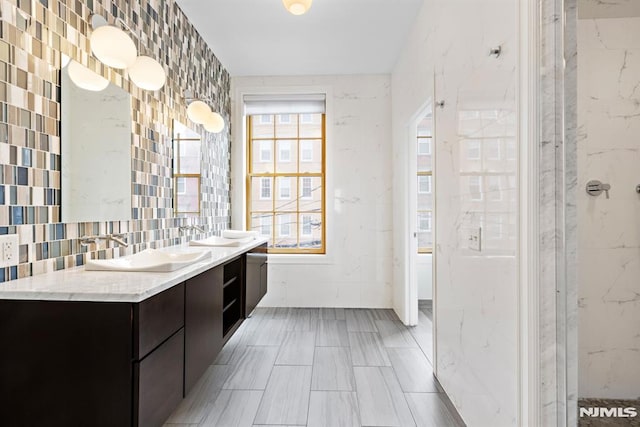 full bath featuring double vanity, a shower, and a sink