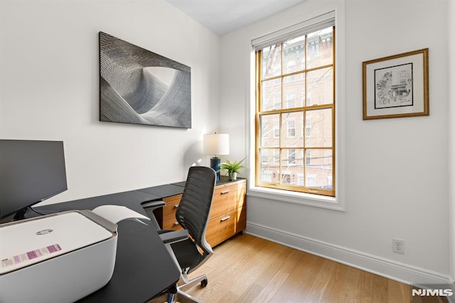 home office with baseboards and light wood-style flooring