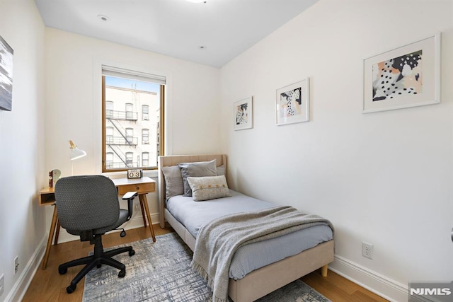 bedroom featuring wood finished floors and baseboards