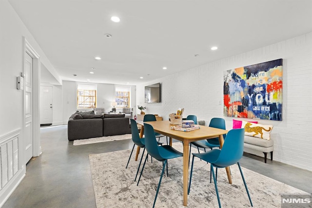 dining space with visible vents, recessed lighting, brick wall, and finished concrete flooring