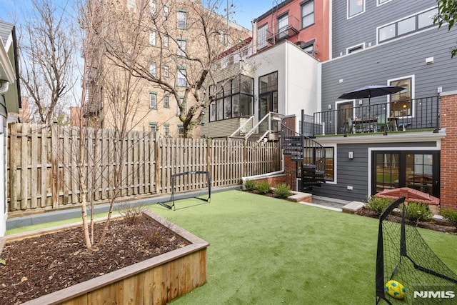 view of yard with stairs and fence