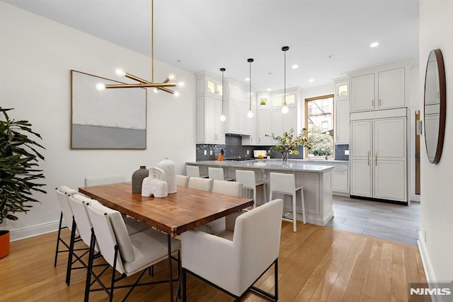 dining room featuring recessed lighting, light wood-type flooring, and baseboards