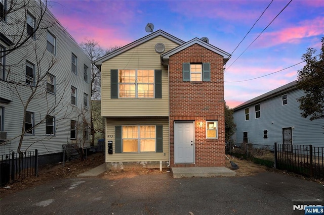 view of front facade featuring fence and brick siding