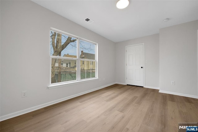 interior space featuring visible vents, a healthy amount of sunlight, baseboards, and light wood finished floors