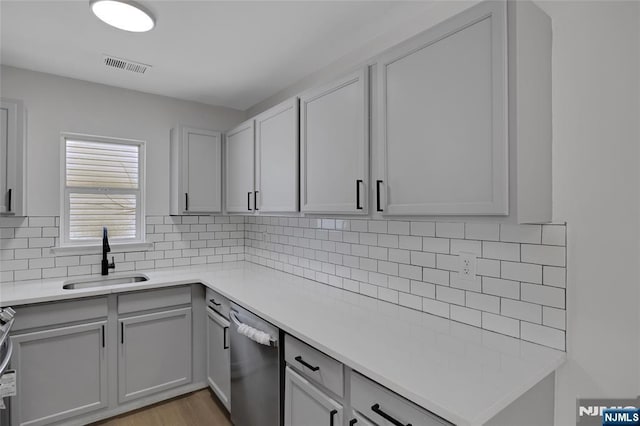 kitchen with visible vents, a sink, tasteful backsplash, appliances with stainless steel finishes, and light countertops