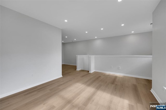 spare room with recessed lighting, light wood-type flooring, and baseboards