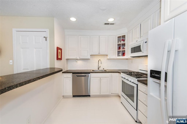 kitchen with white cabinetry, white appliances, visible vents, and a sink