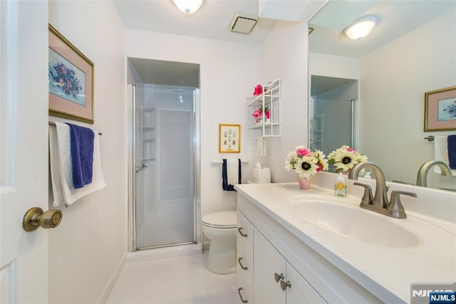 bathroom featuring a stall shower, toilet, vanity, and baseboards