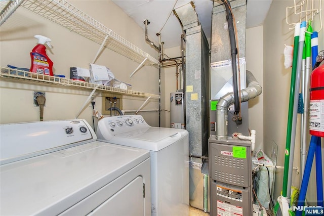 clothes washing area featuring laundry area, independent washer and dryer, and water heater