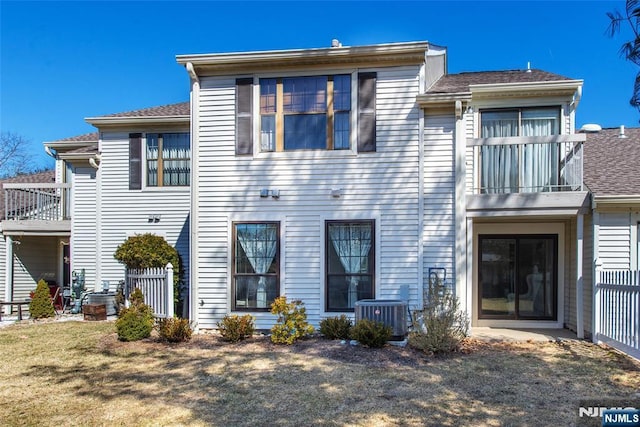 view of front of house featuring a balcony, cooling unit, and fence