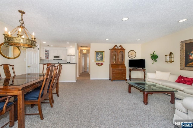 living area featuring baseboards, recessed lighting, a textured ceiling, a notable chandelier, and light colored carpet