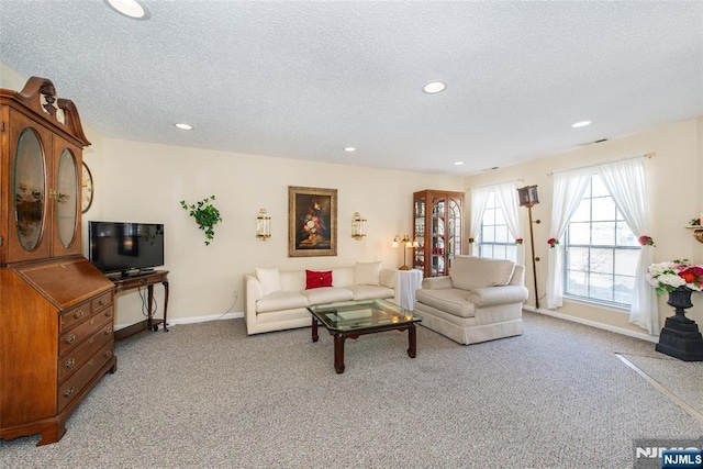 living area with light carpet, recessed lighting, a textured ceiling, and baseboards