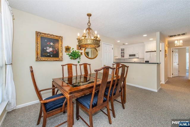 dining space featuring visible vents, light carpet, a textured ceiling, baseboards, and a chandelier