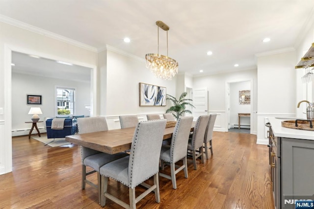 dining space with recessed lighting, ornamental molding, a baseboard radiator, and wood finished floors