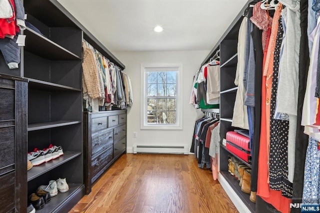 walk in closet with baseboard heating and wood finished floors