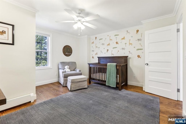 bedroom with a baseboard radiator, wood finished floors, baseboards, and ornamental molding