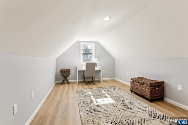 office area with baseboards, lofted ceiling, and light wood-style floors