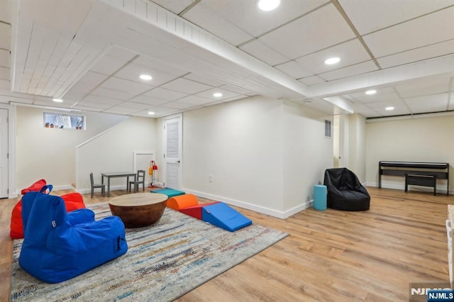 recreation room featuring wood finished floors, visible vents, baseboards, recessed lighting, and a drop ceiling