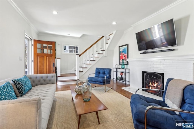 living area featuring crown molding, stairs, recessed lighting, a fireplace, and wood finished floors