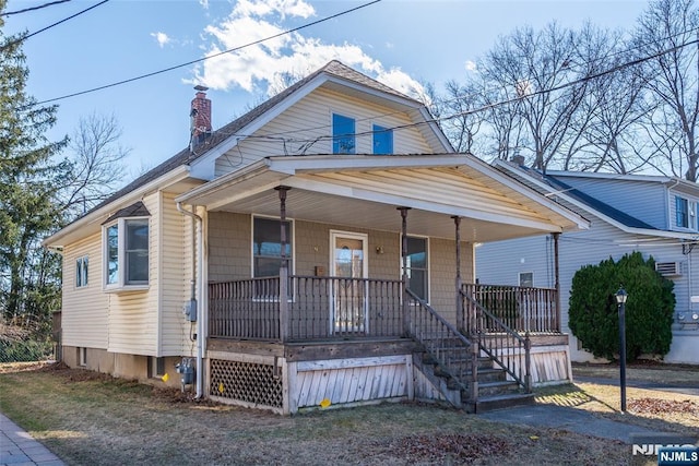 view of front of home featuring covered porch and a chimney