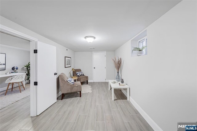 sitting room with baseboards and wood finish floors