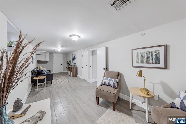 living area with visible vents, baseboards, and light wood-style floors