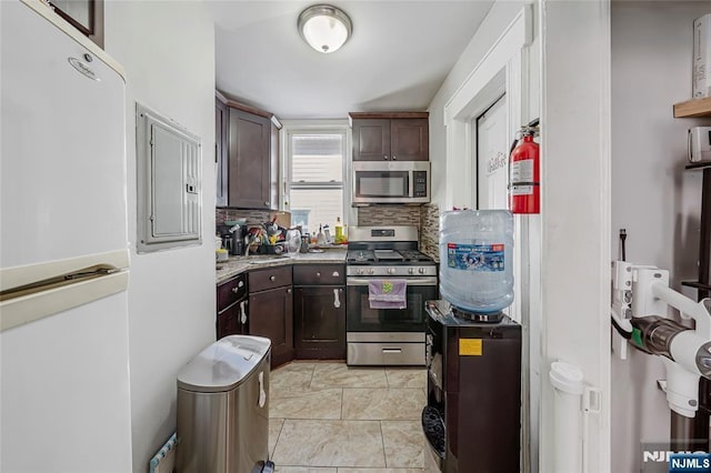 kitchen with decorative backsplash, dark brown cabinetry, and appliances with stainless steel finishes