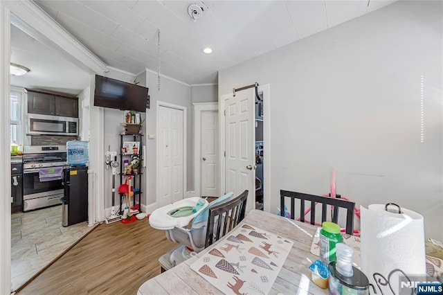 dining area with light wood finished floors, recessed lighting, crown molding, and baseboards