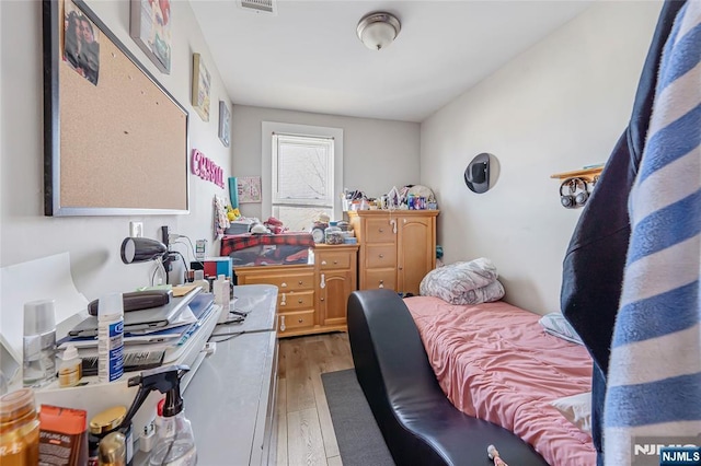 bedroom with light wood finished floors and visible vents