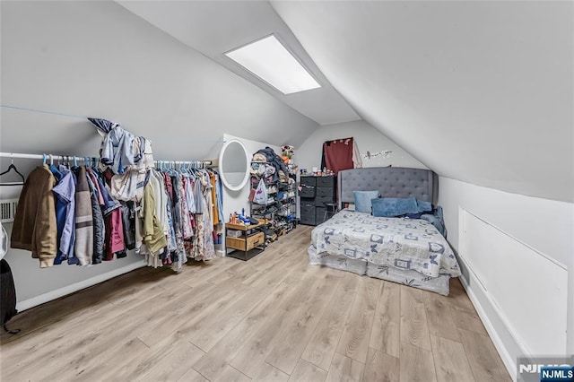 bedroom with lofted ceiling and wood finished floors