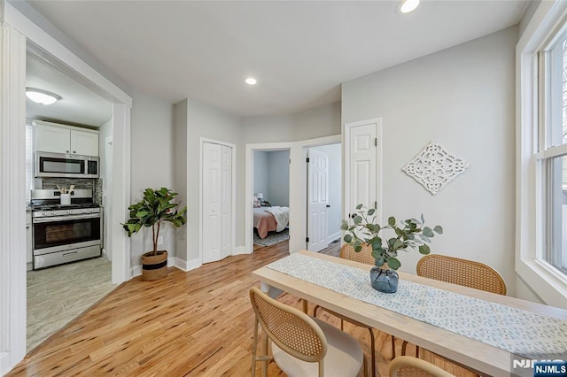 dining space featuring recessed lighting, baseboards, and light wood finished floors