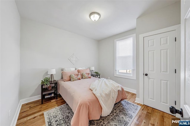 bedroom with light wood finished floors and baseboards