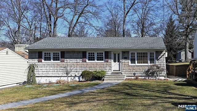 view of front of property featuring a chimney, roof with shingles, a front lawn, and entry steps