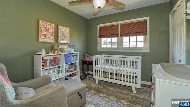 bedroom featuring ceiling fan, baseboards, and wood finished floors