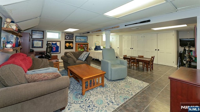 living room with dark tile patterned floors, visible vents, and decorative columns