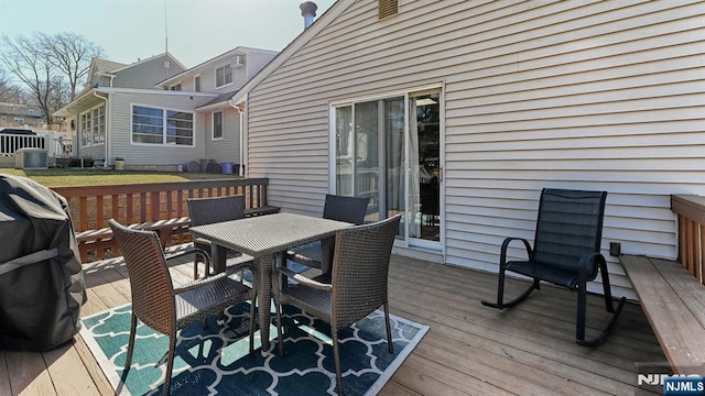 wooden deck featuring outdoor dining area and a grill