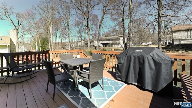 wooden terrace with area for grilling and outdoor dining space