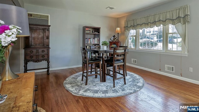 dining room with visible vents, baseboards, and wood finished floors