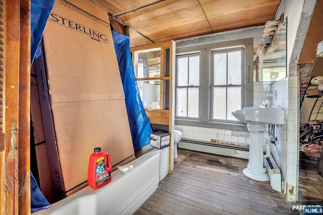 interior space featuring wood ceiling, a baseboard heating unit, and wood finished floors