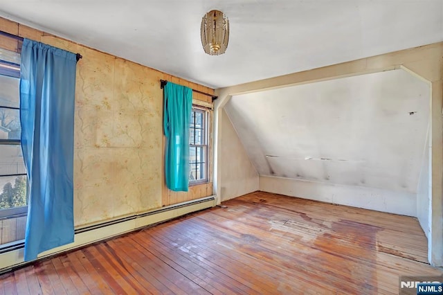 bonus room with vaulted ceiling, a baseboard heating unit, and wood-type flooring