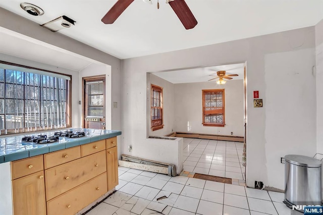 kitchen featuring tile countertops, a ceiling fan, baseboard heating, and light brown cabinetry