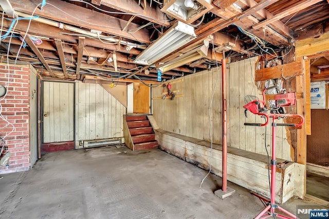 unfinished basement featuring wood walls