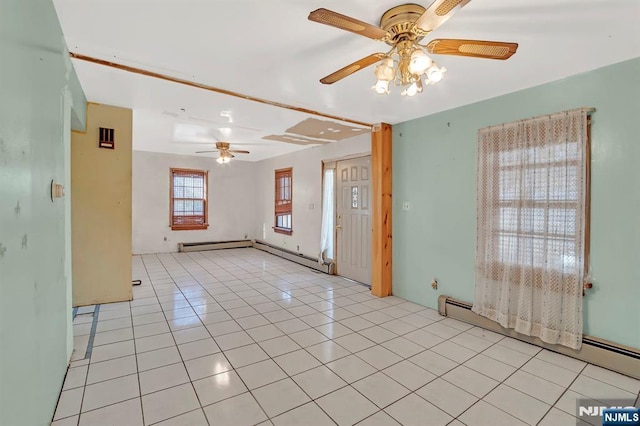 empty room with ceiling fan, light tile patterned floors, and a baseboard radiator