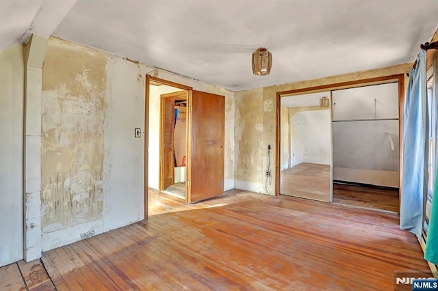 unfurnished bedroom with a closet and hardwood / wood-style floors