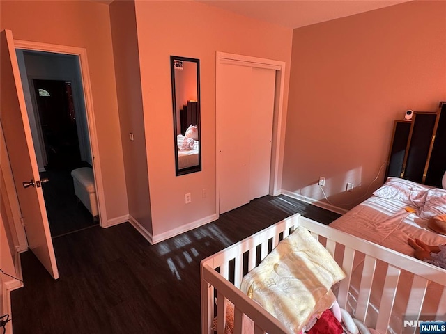 bedroom featuring a closet, baseboards, and wood finished floors