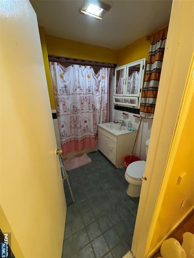 bathroom with curtained shower, toilet, and vanity