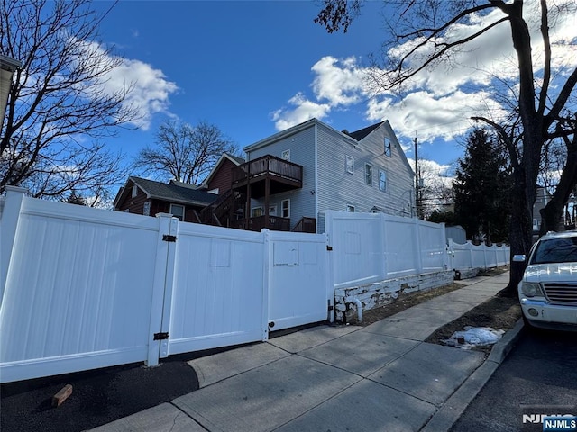 view of side of property featuring fence and a gate