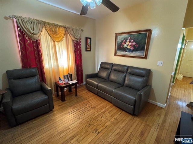 living area featuring hardwood / wood-style flooring, baseboards, and ceiling fan