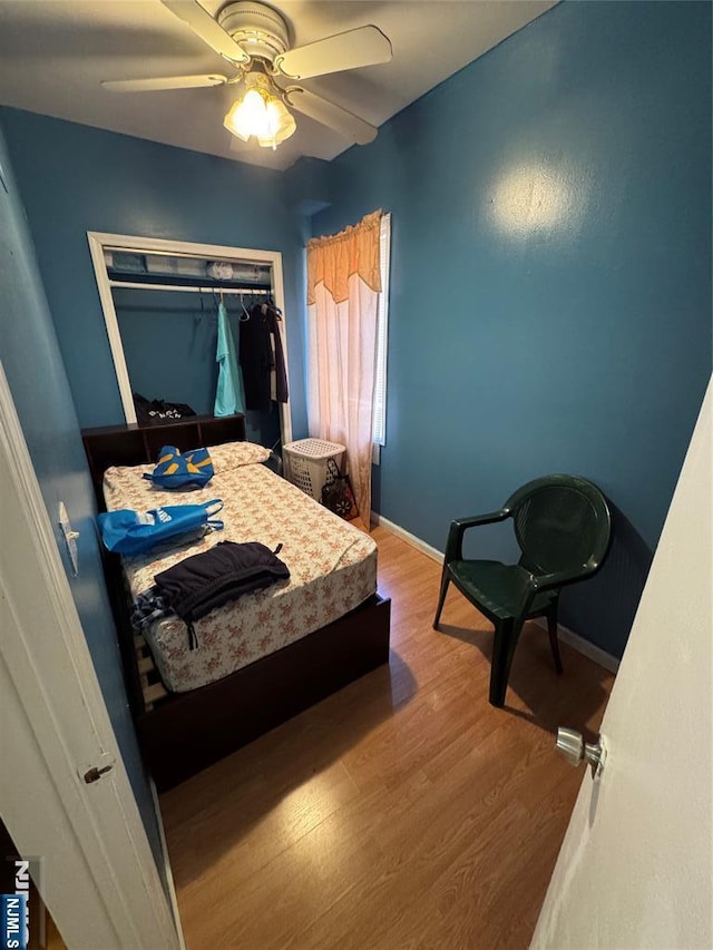 bedroom featuring wood finished floors, baseboards, and ceiling fan